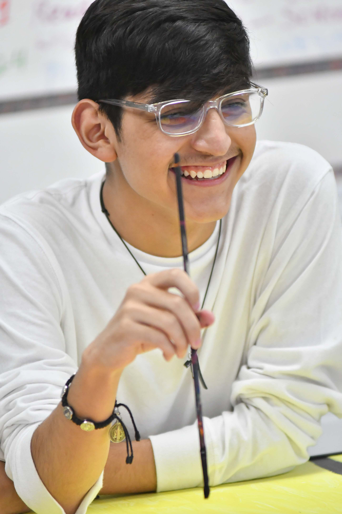 Ethan Chavarria laughs as he pauses painting his mural during Vicki Wimberly’s art class recently.