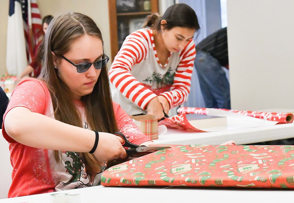 Harley Jarzombek and Dalaney Huber, all Goliad High students, wrap presents Dec. 9 at First United Methodist Church.
